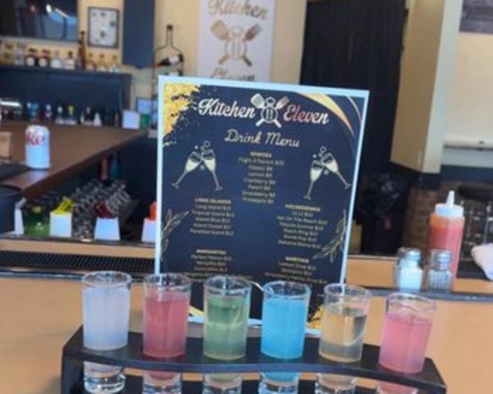 Colorful cocktails lined up along the bar at Kitchen 11 Eleven